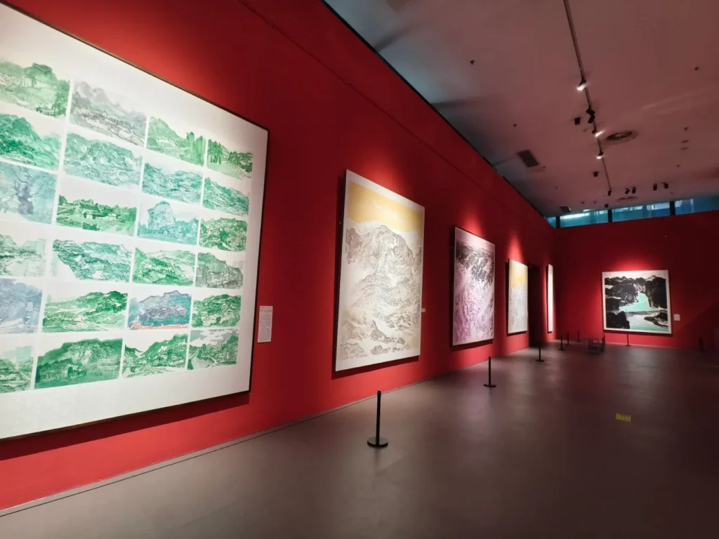 The red walls of the Chongqing Art Museum are covered with landscape paintings.