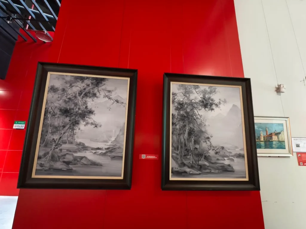 Two ink paintings of trees hang on the red wall of the Chongqing Art Museum.