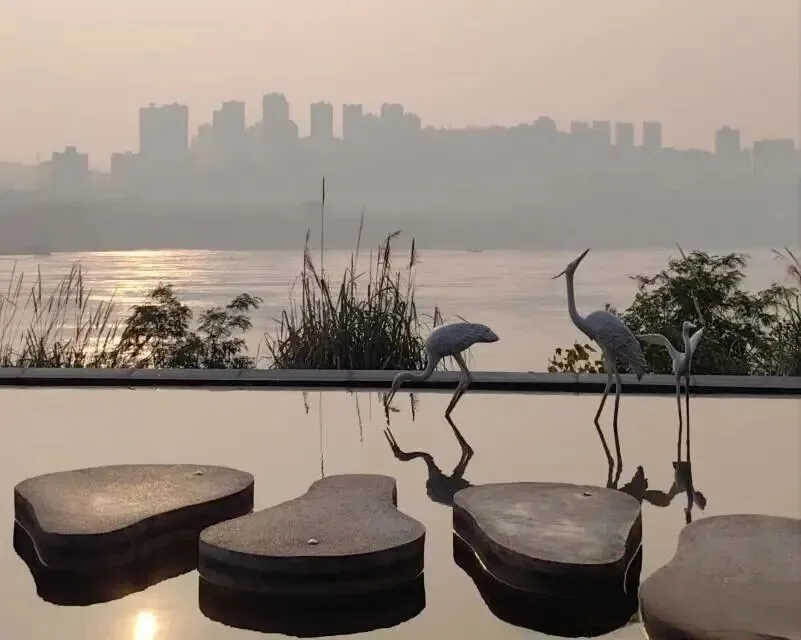 Sunset reflecting in the infinity pool at Chongqing beach with Yangtze River and city skyline in background